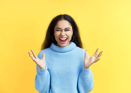Happy excited black woman celebrate success isolated on yellow background