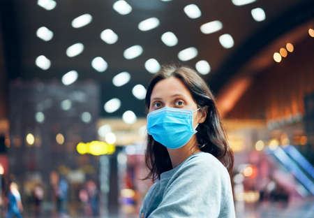 Traveler woman in virus protection face mask in international airportの写真素材