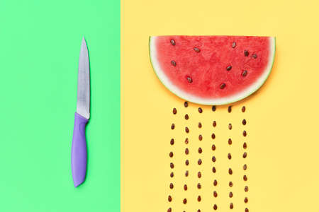 Watermelon slice with seeds and knifeの写真素材