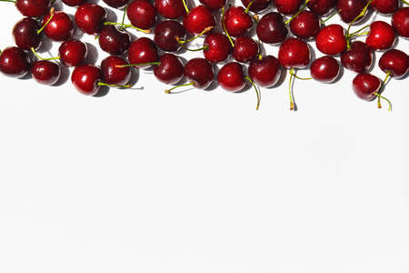 Ripe sweet cherries frame on white background