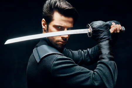 Warrior man posing with a sword ready to stab enemyの写真素材