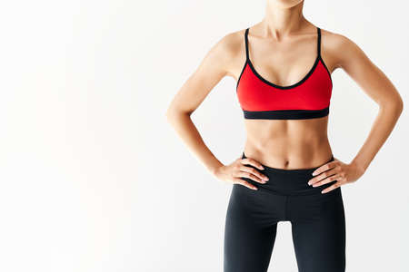 Cropped image of fit woman torso on white background with copy spaceの写真素材