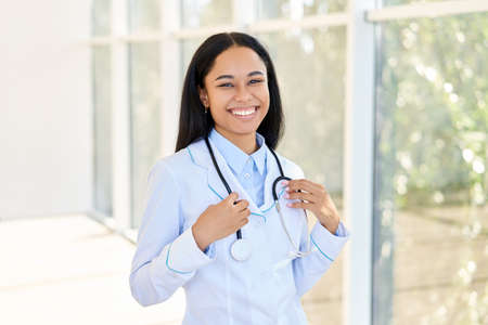 Happy smiling african american female doctor portrait in hospitalの写真素材
