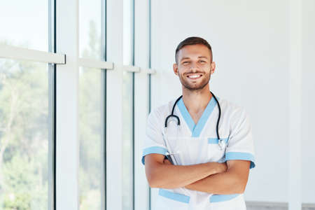 Portrait of confident smiling male doctor with stethoscope in medical uniformの写真素材