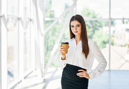 Portrait of elegant businessman with cup of coffee in hand during break time in modern creative...