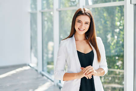 Smiling pretty business woman posing in a modern office with copy spaceの写真素材