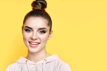 Headshot portrait of young happy woman smiling and looks at camera with copy spaceの写真素材