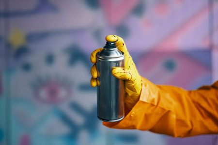 Graffiti artist pointing spray paint can to cameraの写真素材