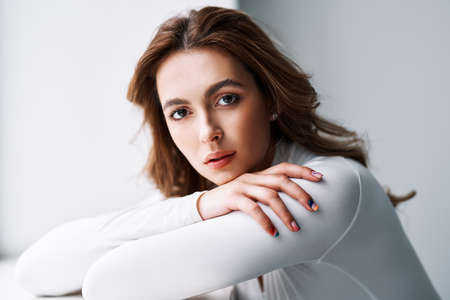 Close up portrait of sensual pretty young woman in white clothesの写真素材