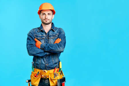 Portrait of confident handsome male construction worker with crossed arms and copy spaceの写真素材
