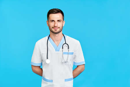 Portrait of confident smiling male doctor with stethoscope in medical uniform with copy