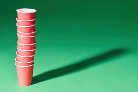 Stack of red paper cup on green backgroundの写真素材