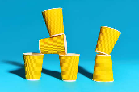 Bright yellow paper cups on blue background