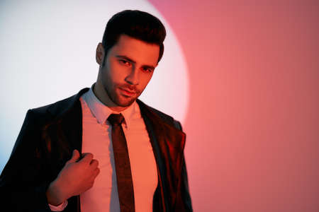 Handsome trendy man posing in the spotlight on studio backgroundの写真素材