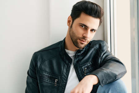 Closeup portrait of handsome trendy man posing on white studio backgroundの写真素材