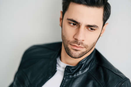 Closeup portrait of handsome thoughtful man posing on white studio backgroundの写真素材