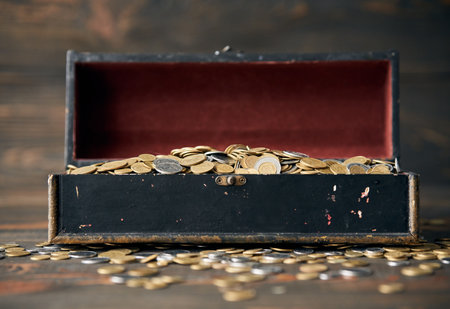 Open treasure chest filled with pile of coins.