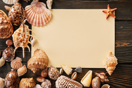 Invitation or greeting card mockup with seashells and starfish on dark woodwn background. Summer...
