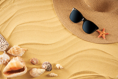 Summer time vacation concept. Straw hat, sunglasses and seashells on the sand beach with copy space for textの写真素材