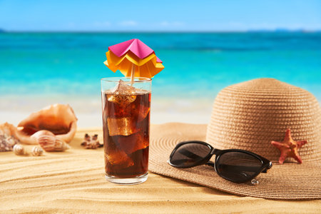 Straw hat, sunglasses and cocktail on the sand and sea background. Relax on the beachの写真素材