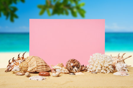 Invitation or greeting card mockup with seashells and starfish on the summer sandy beach at ocean backgroundの写真素材
