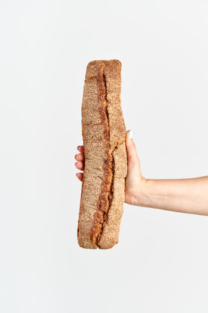 Homemade multigrain bread in woman hand over white background