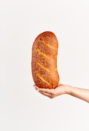 Homemade multigrain bread in woman hand over white backgroundの写真素材