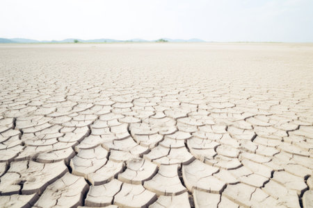 Cracked and arid earth stretching to the horizon under clear sky. Generative AIの素材