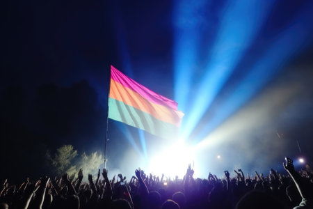Vibrant rainbow flag waving proudly against backdrop of jubilant concertgoers and stage lights at night. Generative AIの素材
