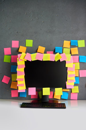 Office workplace with desktop pc full of blank colorful sticky notes
