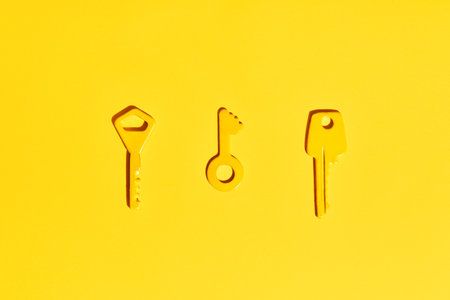 Yellow keys on vibrant yellow background. Flat lay