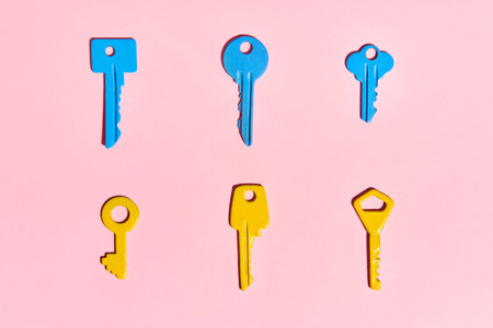 Various colorful keys on pink background. Flat lay