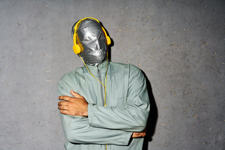 Relaxed mystery man with duct tape face wear headphones listen music