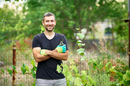 Portrait of smiling gardener posing standing in his garden at summerの写真素材