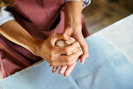 Female potter sculpts from clay at her workshop. raw clay shaping process close-up, top view. Mastering the art of pottery craft ceramicsの写真素材