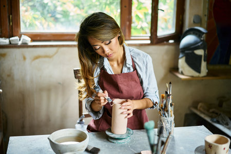 Female artist sculpts crafts with ceramic clay at her creative workshop. Mastering the art of pottery craft ceramicsの写真素材