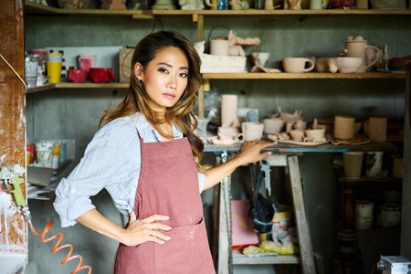 Female artist placing her ceramic clay crafts at pottery kiln. Mastering the art of pottery craft ceramicsの写真素材