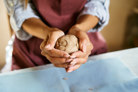 Female potter sculpts from clay at her workshop. raw clay shaping process close-up, top view. Mastering the art of pottery craft ceramicsの写真素材