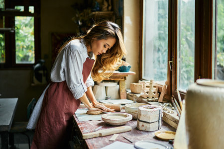 Female potter sculpts from clay at her workshop. raw clay shaping process close up. Mastering the...