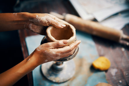 Female artist sculpts crafts with ceramic clay at her creative workshop. Close-up. Mastering the art of pottery craft ceramicsの写真素材