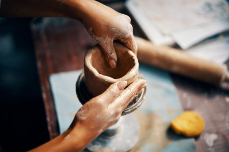 Female artist sculpts crafts with ceramic clay at her creative workshop. Close-up. Mastering the art of pottery craft ceramicsの写真素材