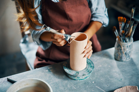 Female artist sculpts crafts with ceramic clay at her creative workshop. Close-up. Mastering the art of pottery craft ceramicsの写真素材