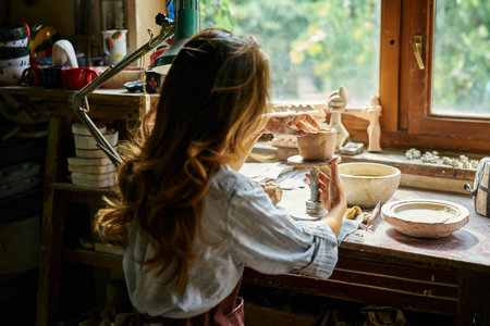 Female artist sculpts crafts with ceramic clay at her creative workshop. Mastering the art of pottery craft ceramicsの写真素材
