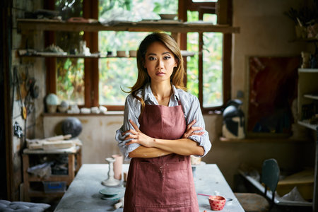 Successful female artist posing at creative workshop with her artwork in the background. Hobby, creative people conceptの写真素材