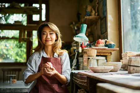 Female potter sculpts from clay at her workshop. raw clay shaping process close up. Mastering the...