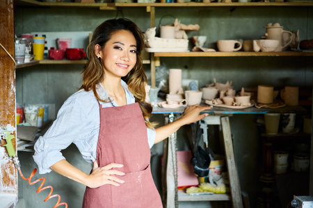 Female artist placing her ceramic clay crafts at pottery kiln. Mastering the art of pottery craft ceramicsの写真素材
