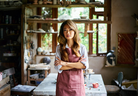 Successful female artist posing at creative workshop with her artwork in the background. Hobby, creative people conceptの写真素材
