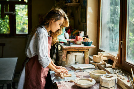 Female potter sculpts from clay at her workshop. raw clay shaping process close up. Mastering the art of pottery craft ceramicsの写真素材