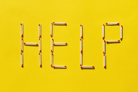 Word HELP spelled with matchsticks on yellow background. Depression, support conceptの写真素材