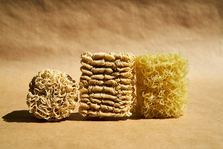 Various dry instant noodle blocks over brown background. Food conceptの写真素材